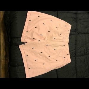 Pink polo shorts with navy blue horses.